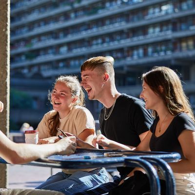 Four students outside on lakeside terrace